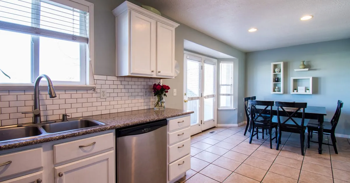 Spacious kitchen and dining area with natural light and modern decor.